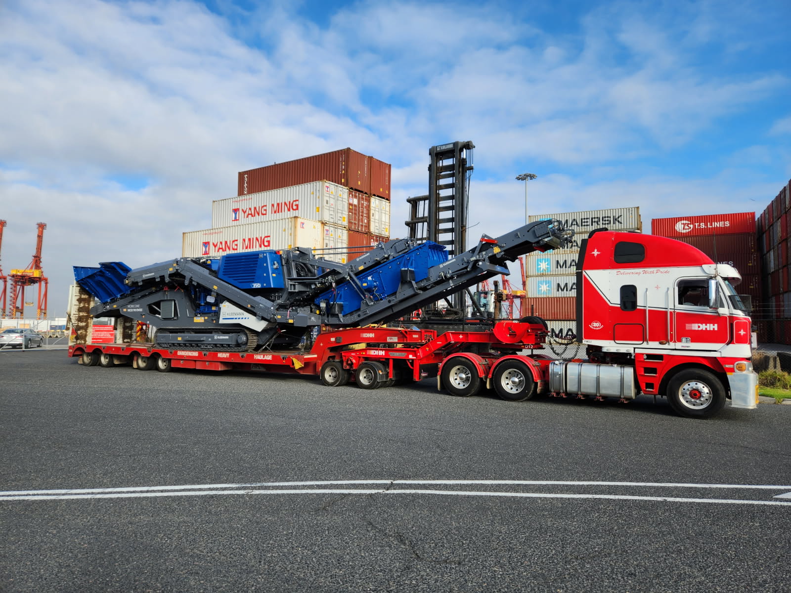 DHH truck carrying blue tracked crushing machinery at the wharf